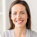 A woman in a gray sweater smiling