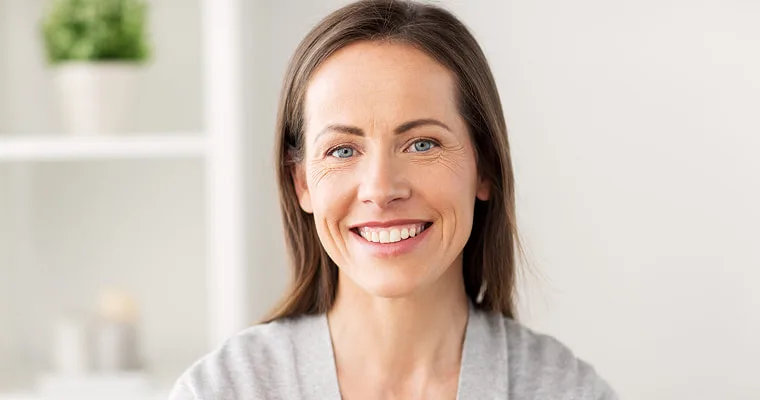 A woman in a gray sweater smiling